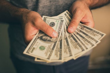 Bir adam dolar elinde tutar.