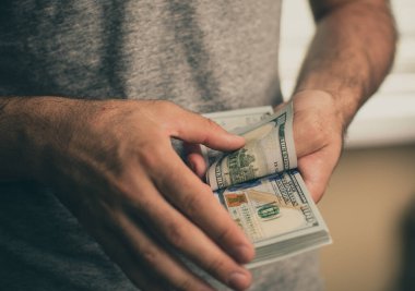 Bir adam dolar elinde tutar.