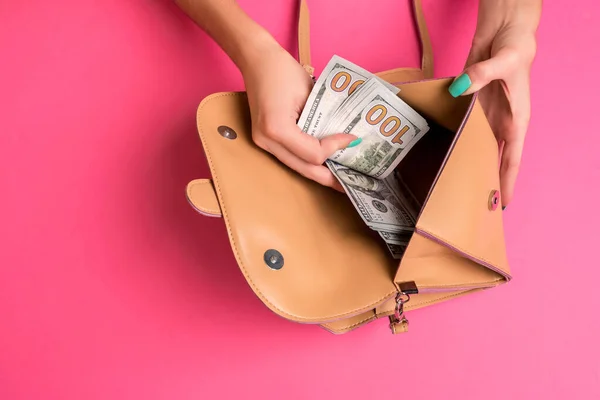 Женская рука снимает деньги из маленькой сумки, студия снимает — стоковое фото