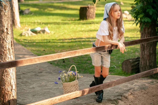 在夏季郊野公园散步时，少女靠在铁栅栏上 — 图库照片