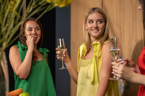 Amistosas chicas jóvenes bebiendo champán y charlando en casa —  Fotos de Stock