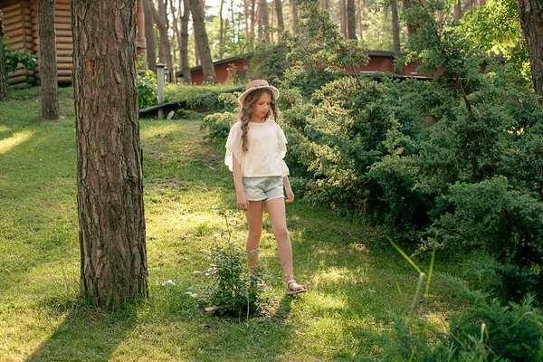 Расслабленная девочка, гуляющая в зеленом парке загородного дома в летний день — стоковое фото