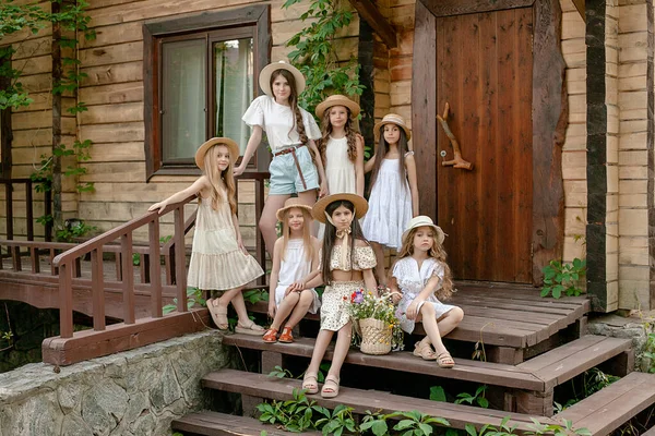 Kleutermeisjes poseren samen op de stoep van het landelijk huisje op zomerdag — Stockfoto