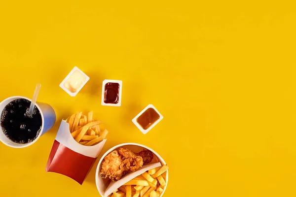 Fast food concept with greasy fried restaurant take out as onion rings, burger, fried chicken and french fries as a symbol of diet temptation resulting in unhealthy nutrition. — Stock Photo, Image