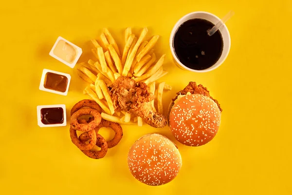 Концепція фаст-фуду з жирним смаженим рестораном виймається як цибулеві кільця, бургер, смажена курка та картопля фрі як символ спокуси дієти, в результаті чого здорове харчування . — стокове фото