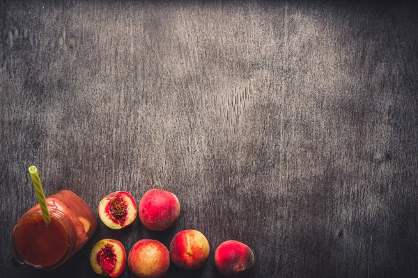 Batido de frutas de melocotón en botella de vidrio y pajitas en mesa de madera. Estilo de vida saludable. Tonificado — Foto de Stock