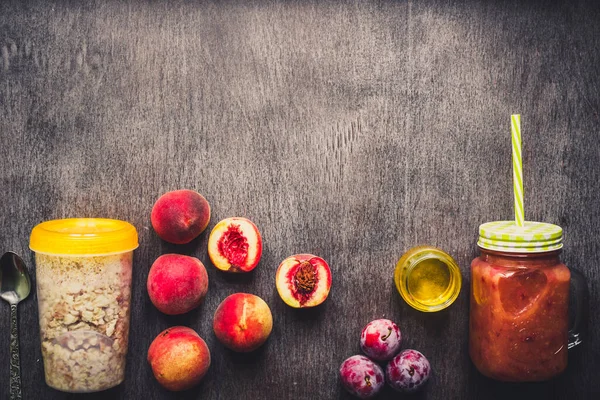 Batido de frutas de melocotón útil en botella de vidrio y pajitas y harina de avena con frutas, desayunos vegetarianos — Foto de Stock