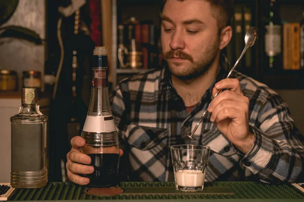 Cantinero enfocado preparando cóctel alcohólico ruso blanco detrás del mostrador de la barra —  Fotos de Stock