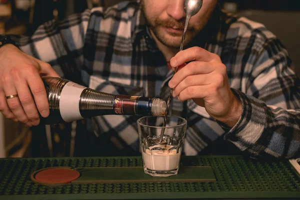 Бармен наливать кофе ликер в стакан со сливками во время приготовления коктейля Белый русский — стоковое фото