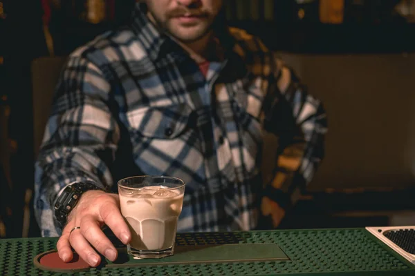 Бармен предлагает коктейль со льдом со сливками и кофе на барной стойке — стоковое фото