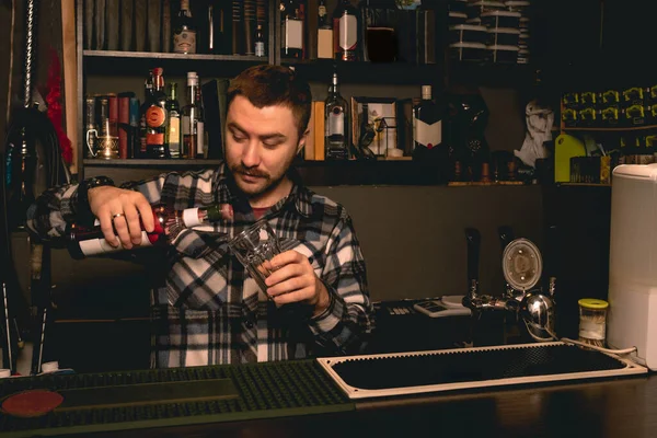 Barman připravuje koktejl za barem, nalévá bobulový likér do skla — Stock fotografie