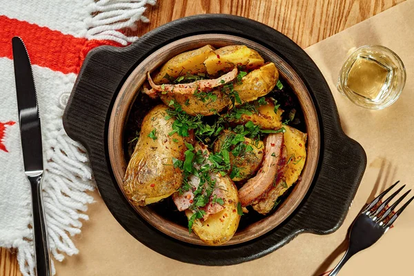У грузинському ресторані, традиційному глиняному кетсі з чачою, готували смажену картоплю з беконом та зеленню. — стокове фото