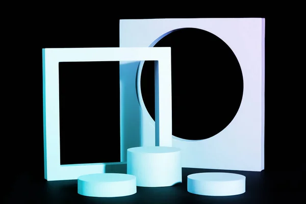 Light blue cylindrical platformes and square on black background — Stock Photo, Image