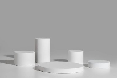 Gri arkaplanda beş silindirli podyum modeli
