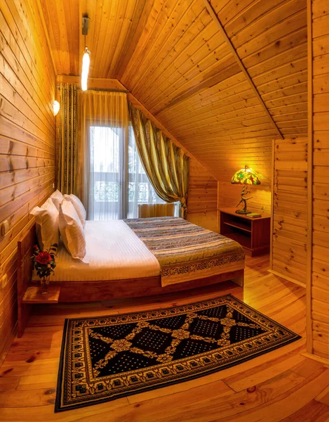 Dormitorio Mansard con adorno de madera natural en casa de campo con cama doble —  Fotos de Stock