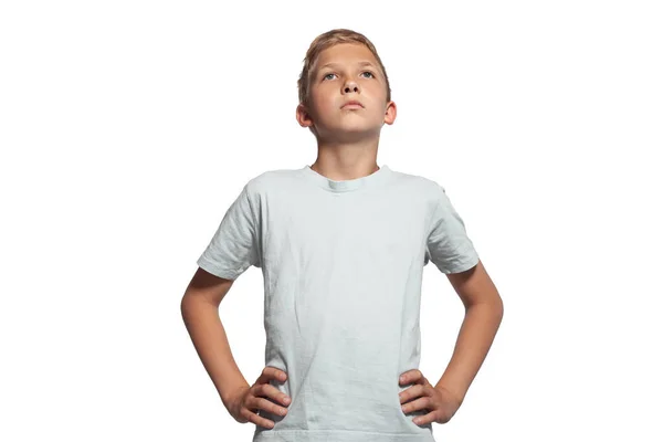 Close-up portrait of a blonde teenage boy in a white t-shirt posing isolated on white studio background. Concept of sincere emotions. — Stock Photo, Image