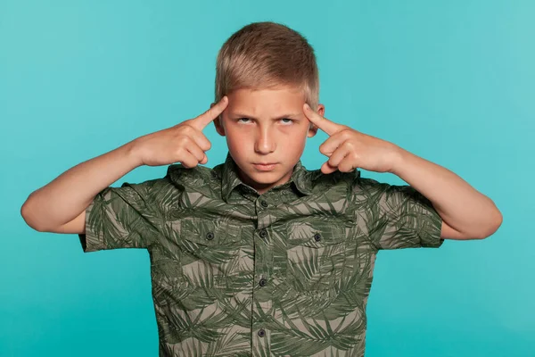 Mavi stüdyo arka planında avuç içi izi olan yeşil tişörtlü genç bir çocuğun yakın plan portresi. Samimi duygular kavramı. — Stok fotoğraf