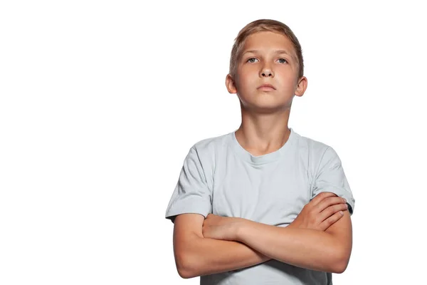 Close-up portret van een blonde tiener jongen in een wit t-shirt poseren geïsoleerd op witte studio achtergrond. Concept van oprechte emoties. — Stockfoto