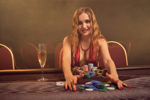 Очаровательная женщина с красивой прической и идеальным макияжем играет в покер. Казино . — стоковое фото