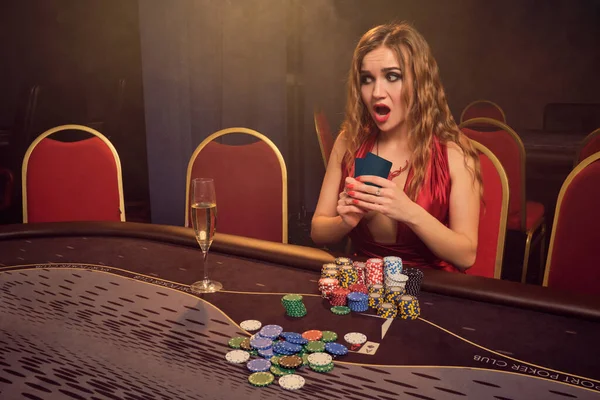 Encantadora mujer con un hermoso peinado y maquillaje perfecto está jugando al poker. Casino Casino . — Foto de Stock