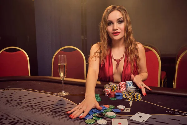 Encantadora mujer con un hermoso peinado y maquillaje perfecto está jugando al poker. Casino Casino . — Foto de Stock