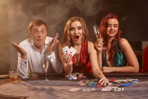 Grupo de jóvenes amigos ricos están jugando al póquer en un casino . — Foto de Stock