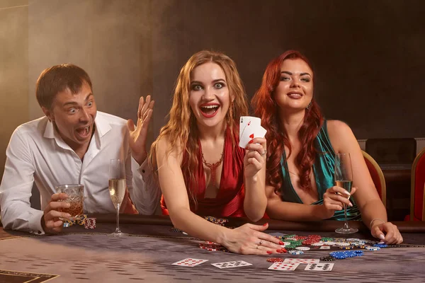 Grupo de jóvenes amigos ricos están jugando al póquer en un casino . — Foto de Stock