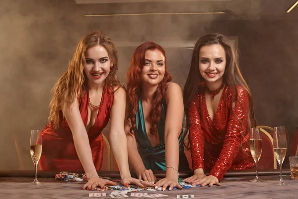 Tre belle giovani donne stanno giocando a poker in un casinò . — Foto Stock