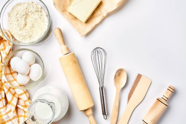 Hamur hazırlığı. Tarifteki malzemelerin miktarının ölçümü. Hamur için malzemeler: un, yumurta, merdane, çırpı, süt, tereyağı, krema. Üst görünüm, metin için boşluk. Devam et