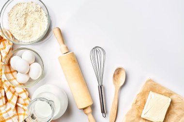 Hamur hazırlığı. Tarifteki malzemelerin miktarının ölçümü. Hamur için malzemeler: un, yumurta, merdane, çırpı, süt, tereyağı, krema. Üst görünüm, metin için boşluk. Devam et