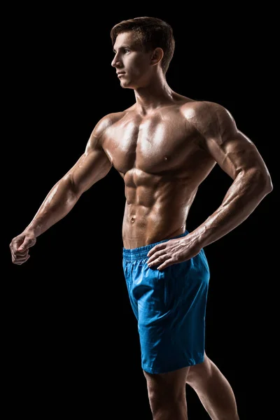 筋肉とフィット若いボディビルダーフィットネス男性モデル黒の背景の上にポーズ 黒い背景にスタジオショット — ストック写真