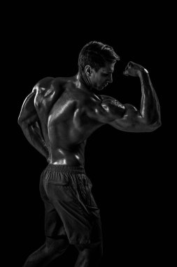 Güçlü Atletik Adam Fitness Modeli sırt kasları, siyah arka plan üzerinde trisepsler. Siyah arkaplanda stüdyo çekimi.