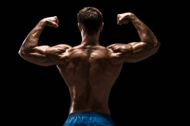 Güçlü Atletik Adam Fitness Modeli sırt kasları, siyah arka plan üzerinde trisepsler. Siyah arkaplanda stüdyo çekimi.