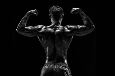Güçlü Atletik Adam Fitness Modeli sırt kasları, siyah arka plan üzerinde trisepsler. Siyah arkaplanda stüdyo çekimi.