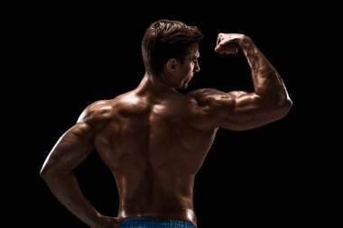 Güçlü Atletik Adam Fitness Modeli sırt kasları, siyah arka plan üzerinde trisepsler. Siyah arkaplanda stüdyo çekimi.