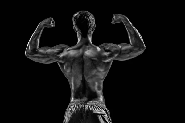 強いアスレチックマンフィットネスモデルは 背中の筋肉をポーズ 黒の背景にトリップ 黒を背景に撮影したスタジオ — ストック写真