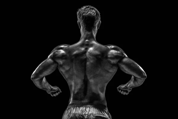 強いアスレチックマンフィットネスモデルは 背中の筋肉をポーズ 黒の背景にトリップ スタジオは黒を背景に撮影 黒と白 — ストック写真