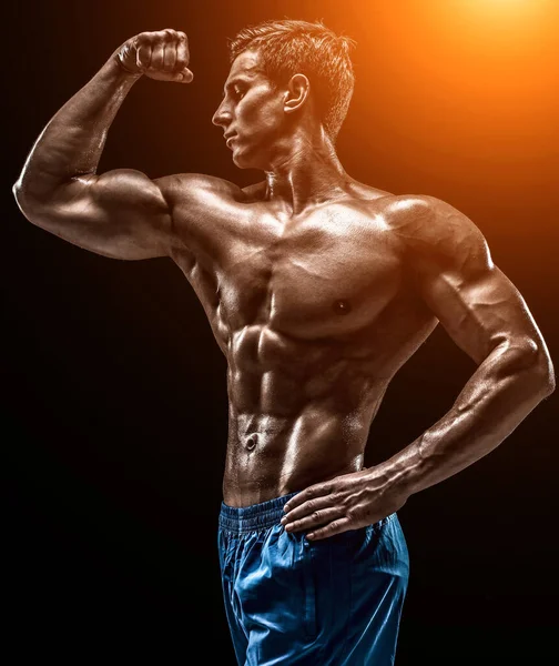 肌肉发达 体格健康的年轻健美男模 造型略带黑色背景 工作室拍摄黑色背景 用太阳耀斑 — 图库照片