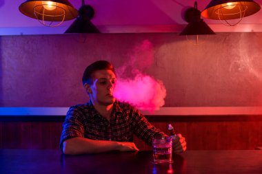 Adam vape dükkanında elektronik sigara içiyor. Bağlantı çubuğu.