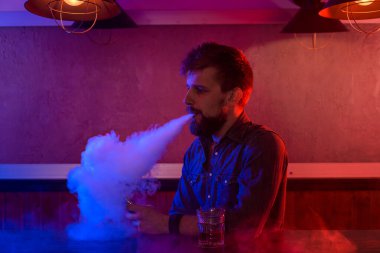 Adam vape dükkanında elektronik sigara içiyor. Bağlantı çubuğu.