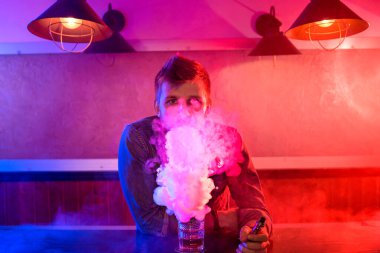 Adam vape dükkanında elektronik sigara içiyor. Bağlantı çubuğu.