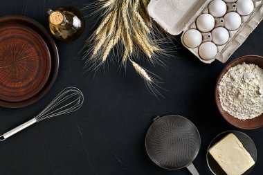 Hamur hazırlama tarifi ekmeği, pizza ya da turta yapma malzemeleri mutfak masasının arkasında düz bir şekilde duruyordu. Tereyağı, maya, un, yumurta ve yağla çalışıyor. Hamur işi mi fırın mı? Üst Manzara. Durgun hayat