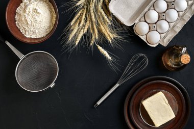 Hamur hazırlama tarifi ekmeği, pizza ya da turta yapma malzemeleri mutfak masasının arkasında düz bir şekilde duruyordu. Tereyağı, maya, un, yumurta ve yağla çalışıyor. Hamur işi mi fırın mı? Üst Manzara. Durgun hayat