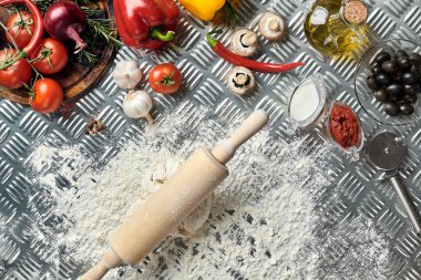 İçindekiler ve hamurlar, taze karışık hamur yığınları, bir kavanoz zeytin yağı ve domates sosu üzerine genel manzaralı pizzalar yapmak için, metal arka planda. Üst Manzara. Düz yatıyordu