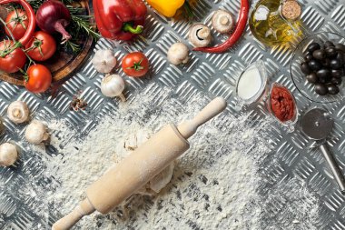 İçindekiler ve hamurlar, taze karışık hamur yığınları, bir kavanoz zeytin yağı ve domates sosu üzerine genel manzaralı pizzalar yapmak için, metal arka planda. Üst Manzara. Düz yatıyordu