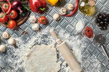 İçindekiler ve hamurlar, taze karışık hamur yığınları, bir kavanoz zeytin yağı ve domates sosu üzerine genel manzaralı pizzalar yapmak için, metal arka planda. Üst Manzara. Düz yatıyordu