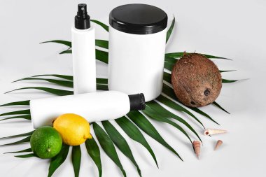 Ev kaplıcası için doğal kozmetik ürünleri. Üst düzey krema şişeleri, şampuan, gerekli yağlı maske, taze limon meyvesi, yeşil yaprak dekoru, beyaz arka plan. Durgun hayat. Uzayı kopyala Doğal güzellik ürünleri