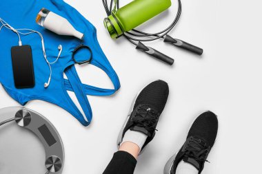 Spor yapan kadın antrenmandan sonra oturup dinleniyor ya da spor salonunda protein içeceği ya da yerde içme suyu ile egzersiz yapıyor. Rahat ol. Kuvvet eğitimi ve Vücut Geliştirme teması. Üst Manzara. Düz yatıyordu
