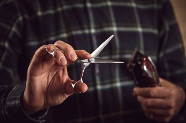Man hairdresser. Barber is holding scissors and razor in his hands barbershop.