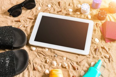 Online poker oyunu ile dijital tablet ve fiş destesi şeklinde sahilde. Üstten Görünüm. Uzay kopyalayın. Düz yatıyordu. Güneş parlaması